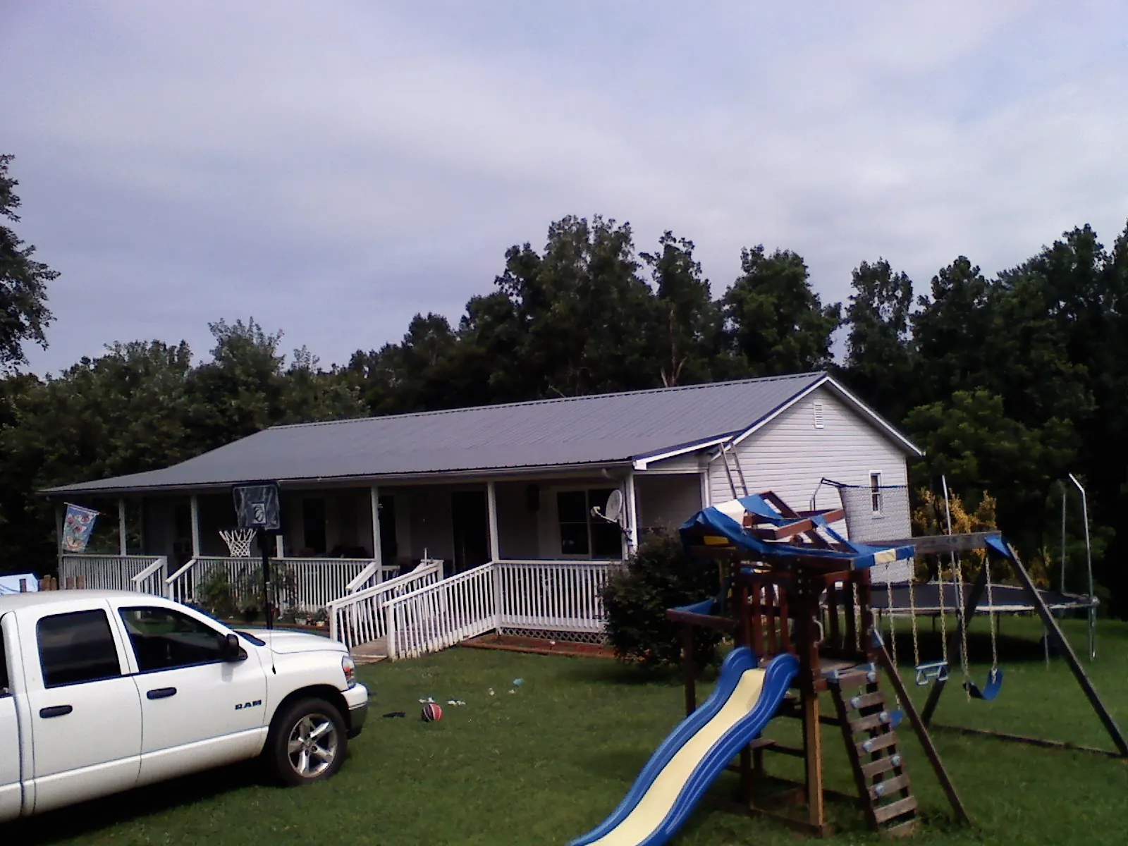 Dark metal roof on a country home with a full length front porch in Madison Heights