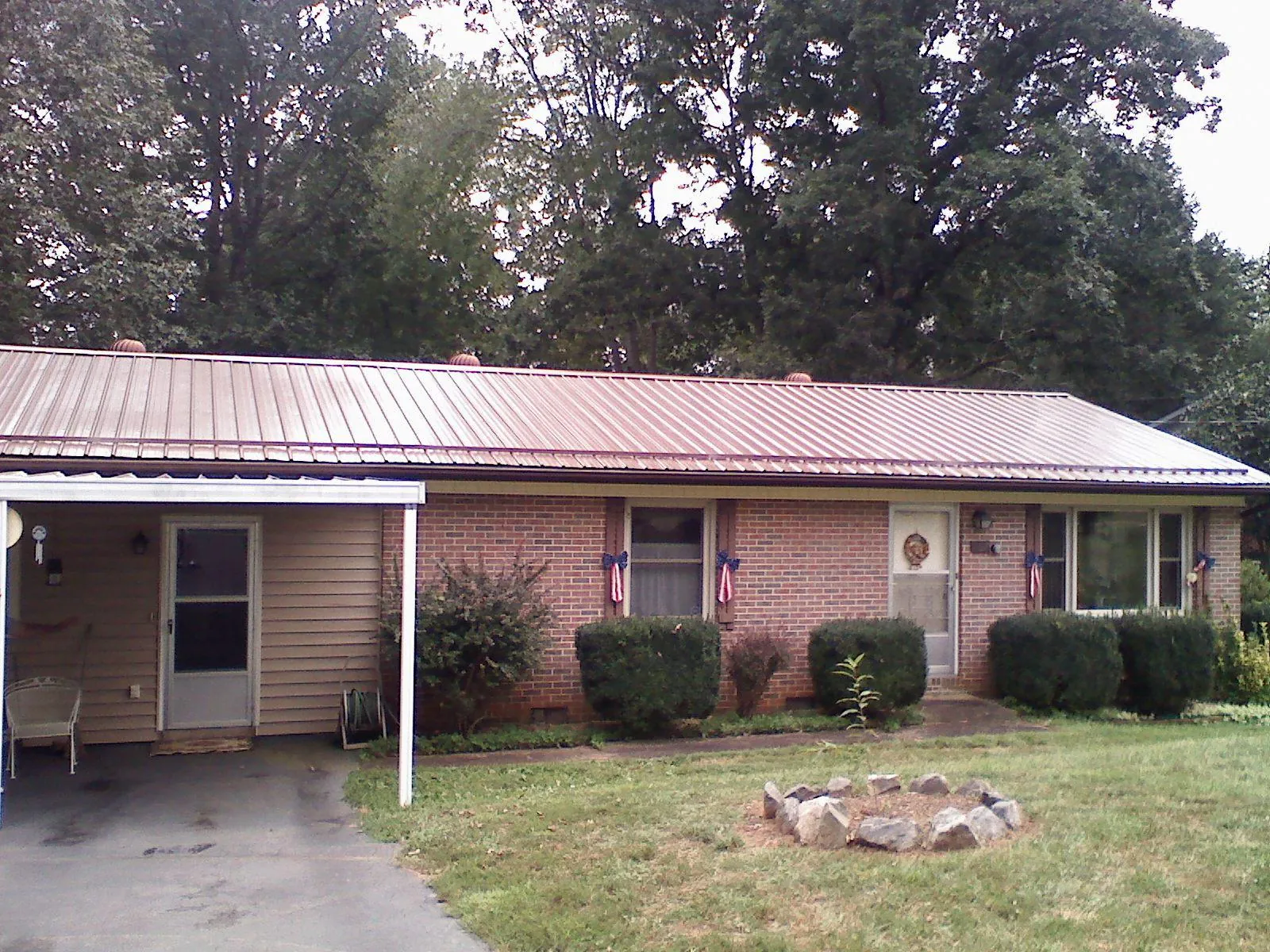 Bronze metal roof and carport on a brick ranch home — Roof Repair work by our crew in Madison Heights