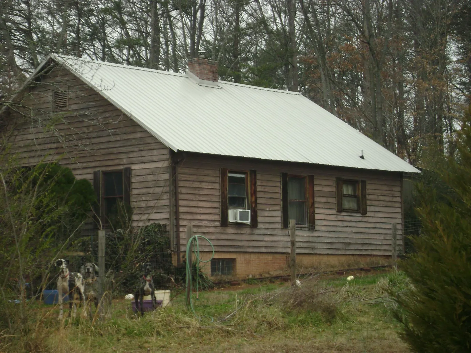 White metal roof on an old wood sided farmhouse, from a Metal Roof Installation job in Madison Heights
